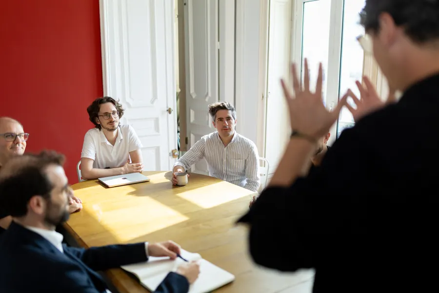 A workshop around a table: a team listening to a presentation