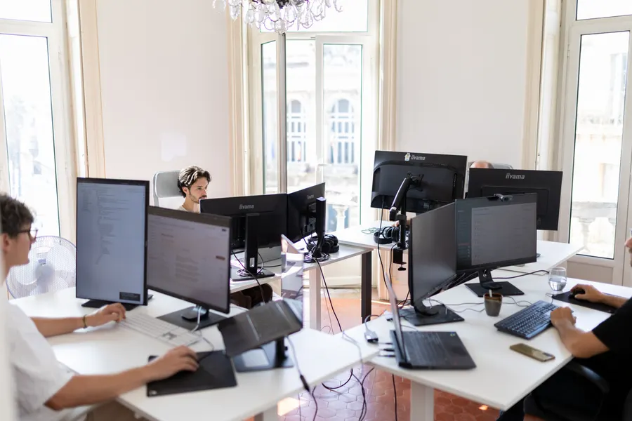 The team’s bright open space, screens and tall windows