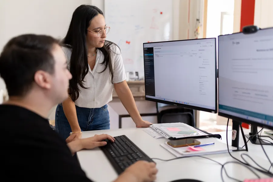 Two Renewr team members working in front of the Renewr app on screen